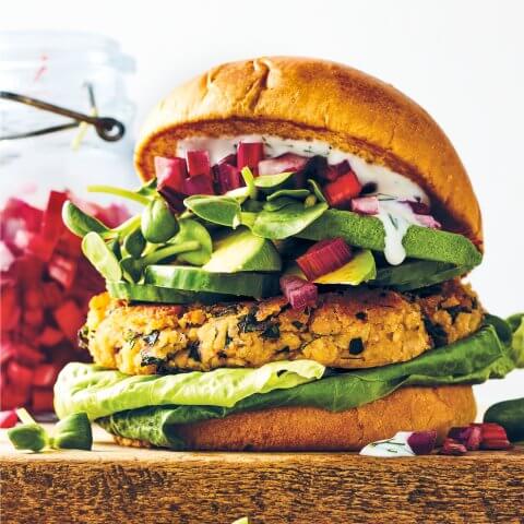 A veggie burger sitting on a wooden block