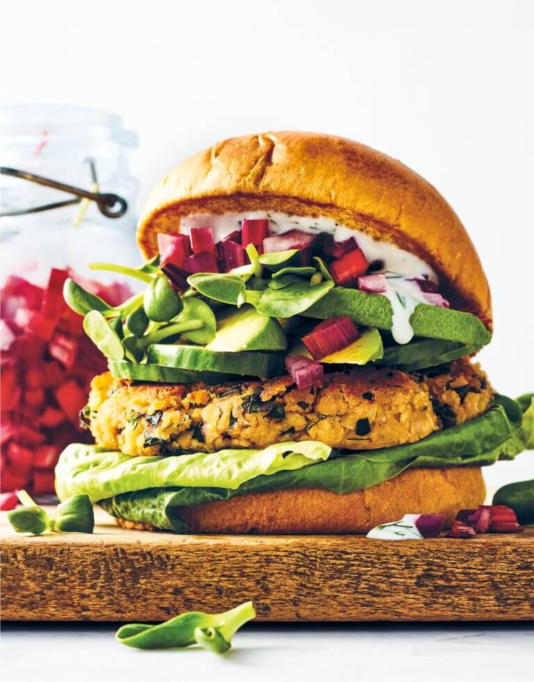A veggie burger sitting on a wooden block
