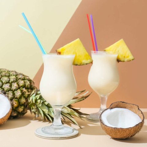 Glasses with Pina Colada cocktail on light background