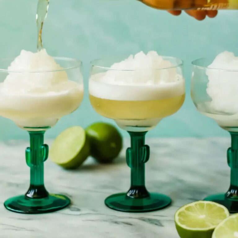 Beer being poured into frozen margaritas served in salt-rimmed glasses.