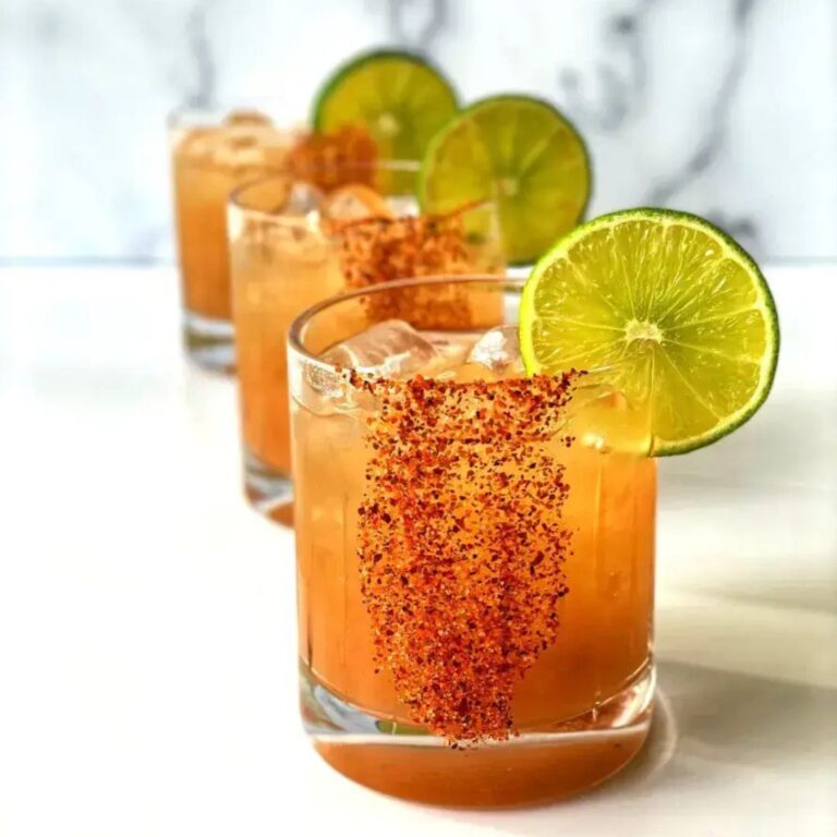 Tamarind margaritas garnished with lime wedges.