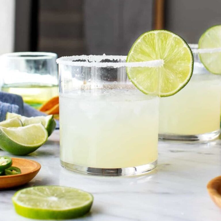 Classic margaritas with salted rims and fresh lime wedges.