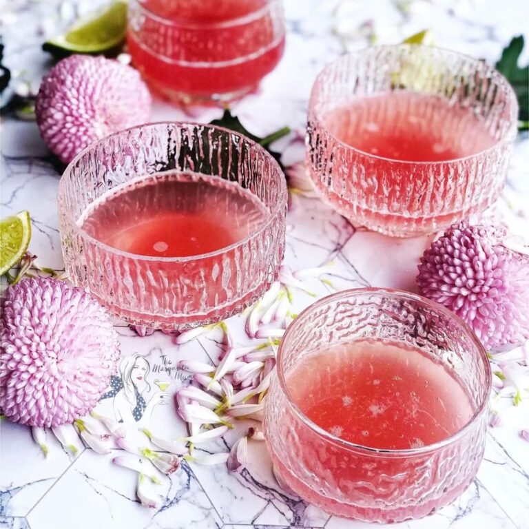 Pink rhubarb margarita garnished flowers.