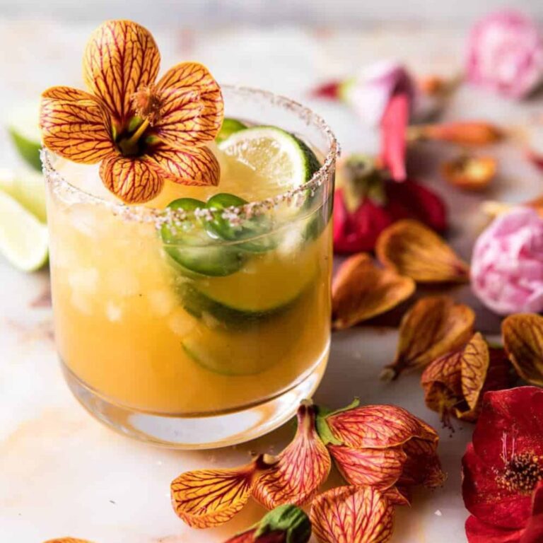 Spicy mango margarita garnished with edible flowers.