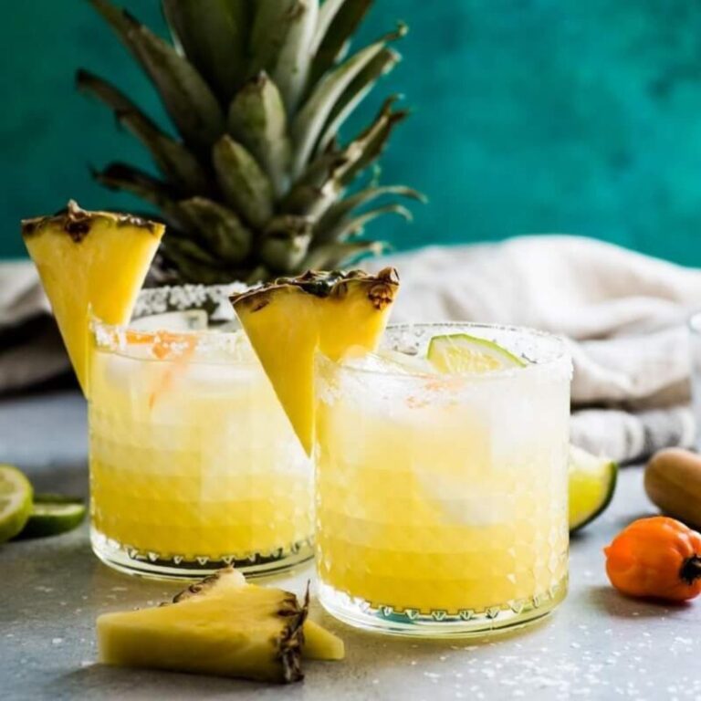 Pineapple margarita garnished with pineapple wedges and jalapeño slices.