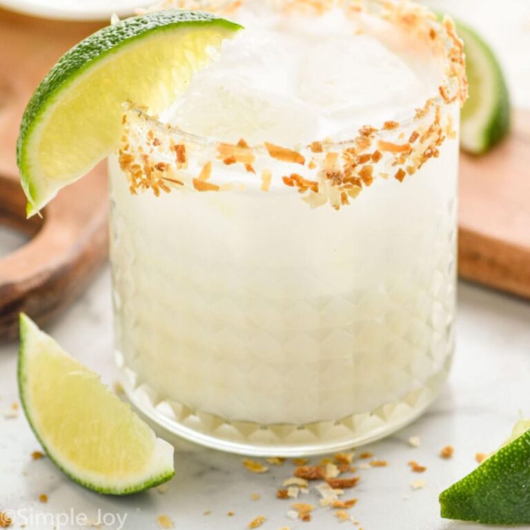Coconut margarita with a toasted coconut rim and lime wedge.
