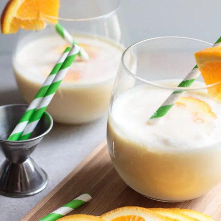 Creamsicle margaritas garnished with orange slices and graham cracker crumbs.