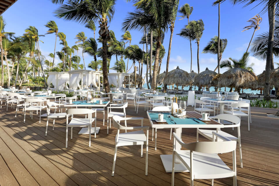 An outdoor dining patio with palm trees 
