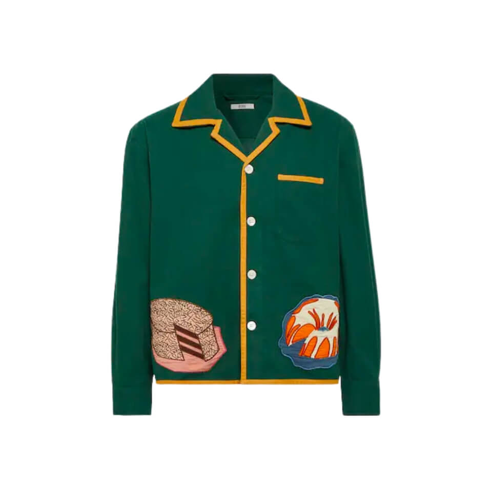 A dark green button-up shirt with desserts embroidered on the hem and yellow trim