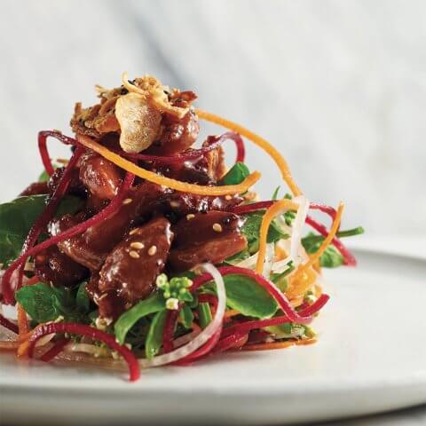 A salad on a white plate crispy duck salad recipe by Chef David Hawksworth