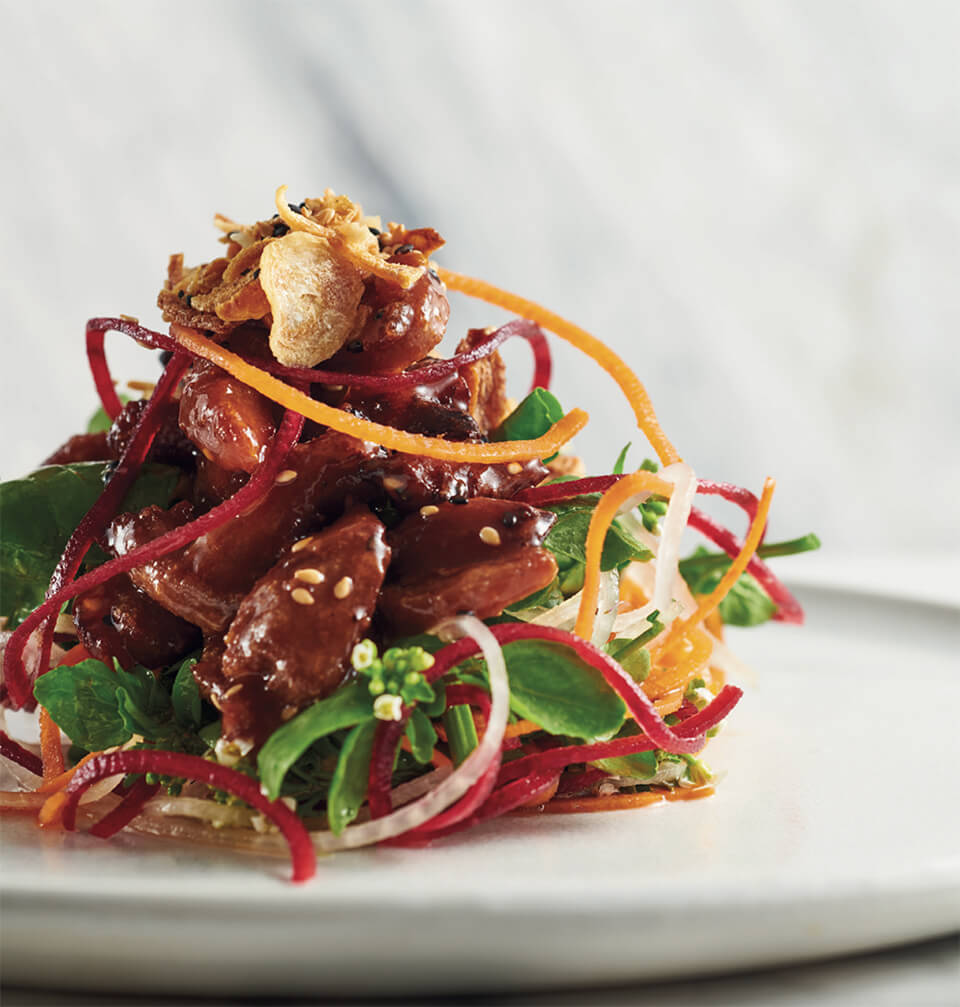 A salad on a white plate crispy duck salad recipe by Chef David Hawksworth
