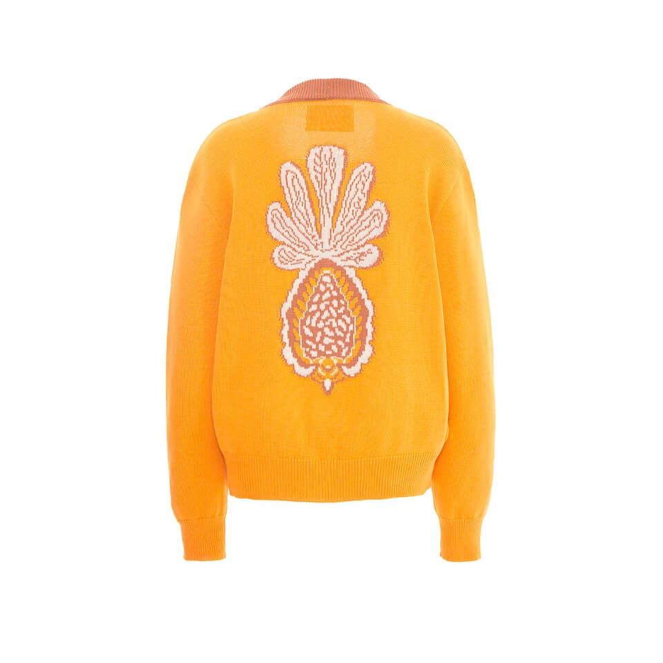 The back of a bright yellow cardigan with a white pineapple design