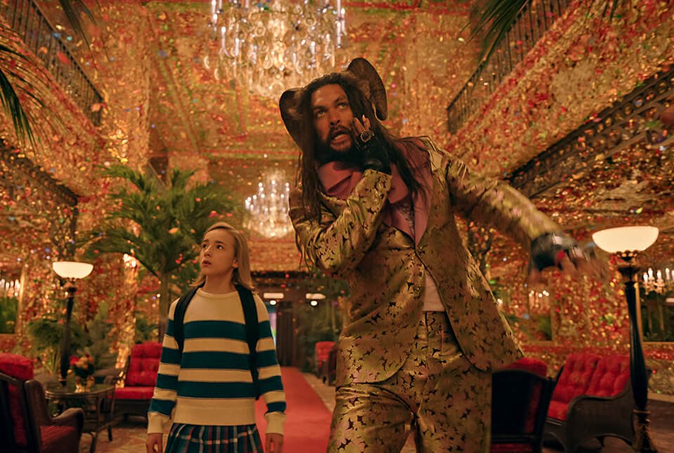 A man and a girl walk through a ballroom filled with butterflies