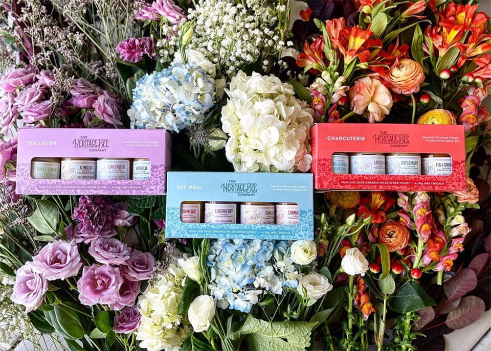 Three boxes of assorted honey in a bed of flowers