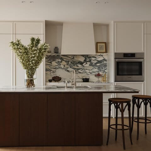 A kitchen panelled in dark wood with white cabinetry