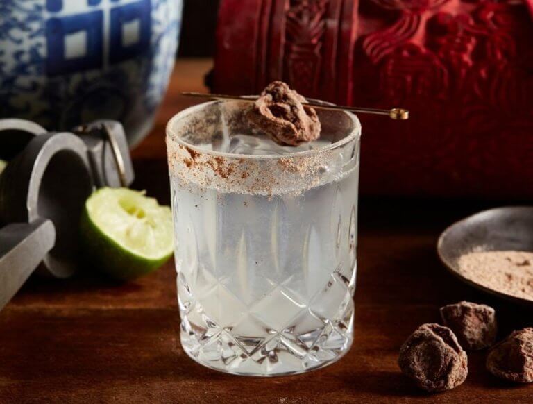 A cocktail garnished with a piece of salted plum