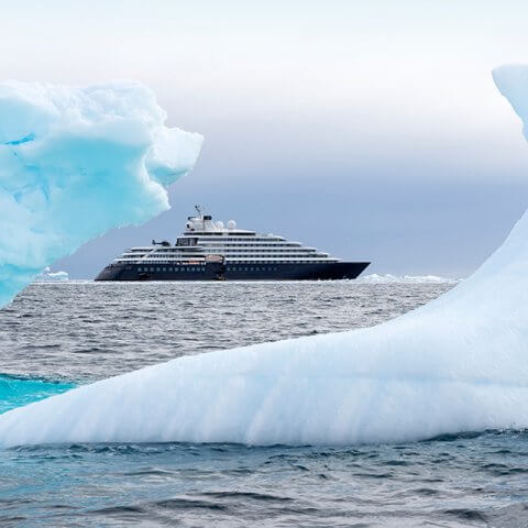 A view of a cruise ship from between ice bergs