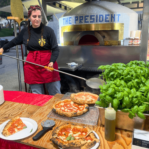 woman standing in front of pizza oven
