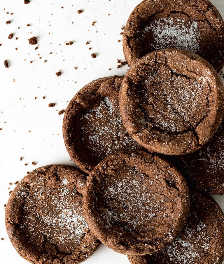 A pile of chocolate cookies on a white surface