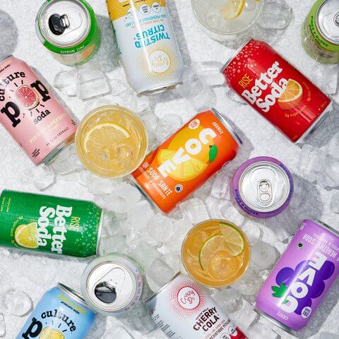 Various cans of soda scattered amongst ice