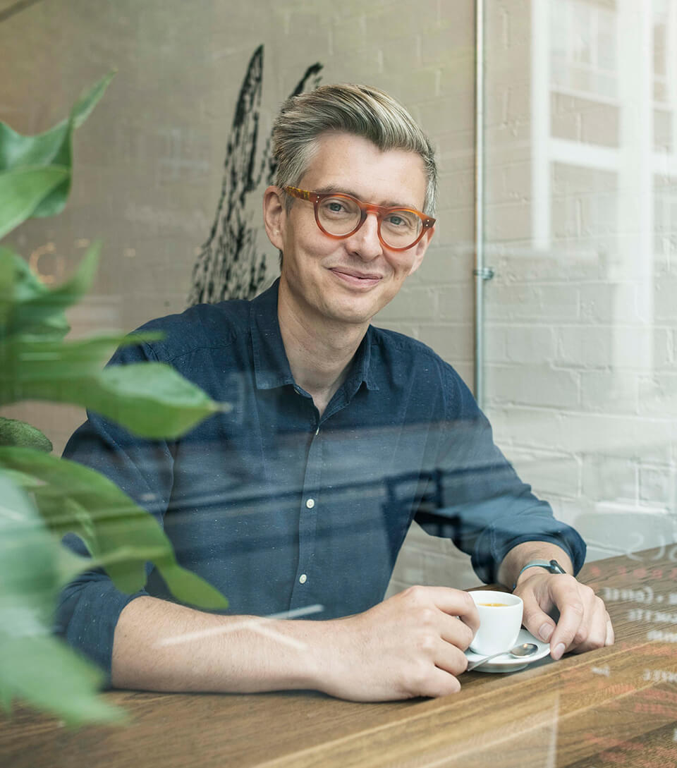 A man sitting at a counter with a cup of coffee