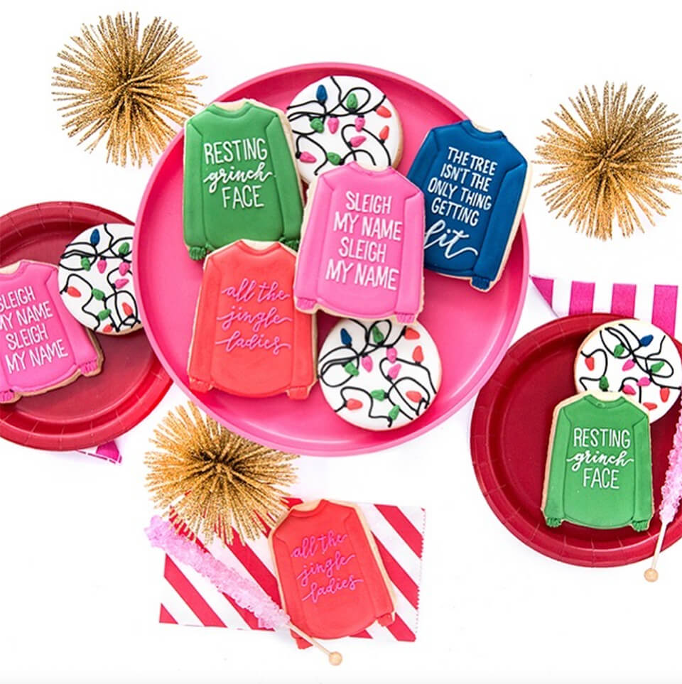 Cookies shaped like shirts and frosted with various phrases