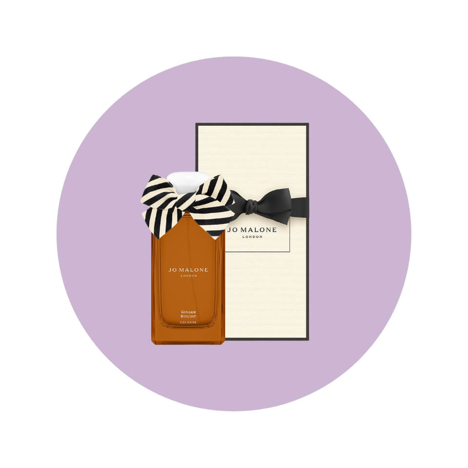 A brown bottle of perfume with a black-and-white striped bow as well as a gift box in a light purple circle