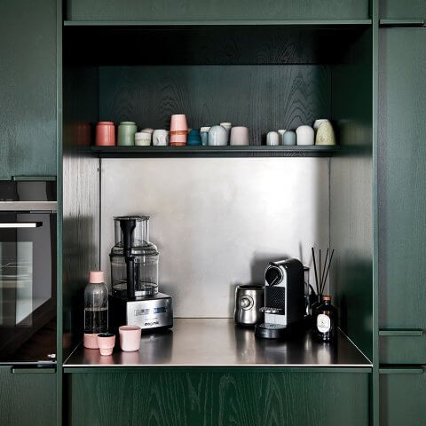 A home coffee bar with dark green panelling