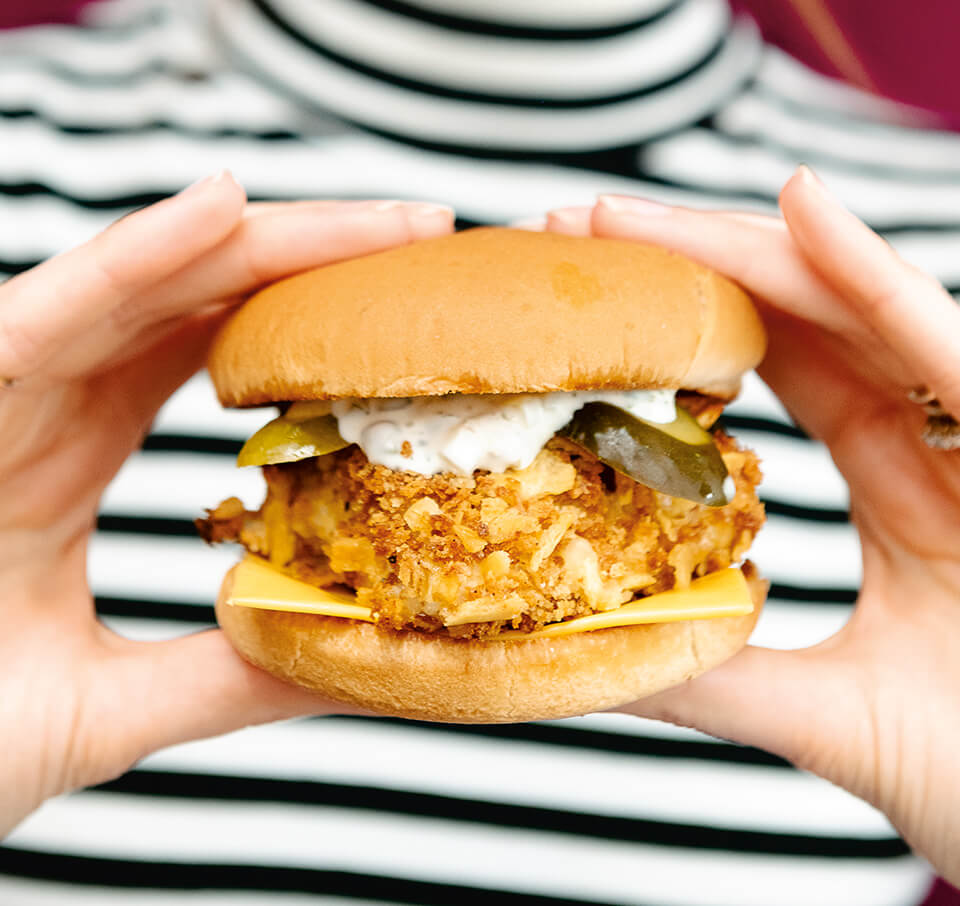 A woman holding a fish sandwich