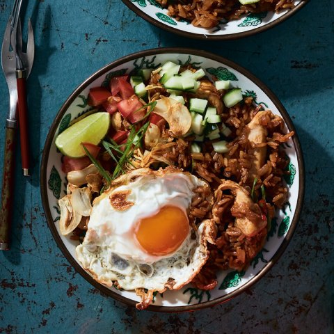 Bowls of Indonesian nasi goreng on a blue surface
