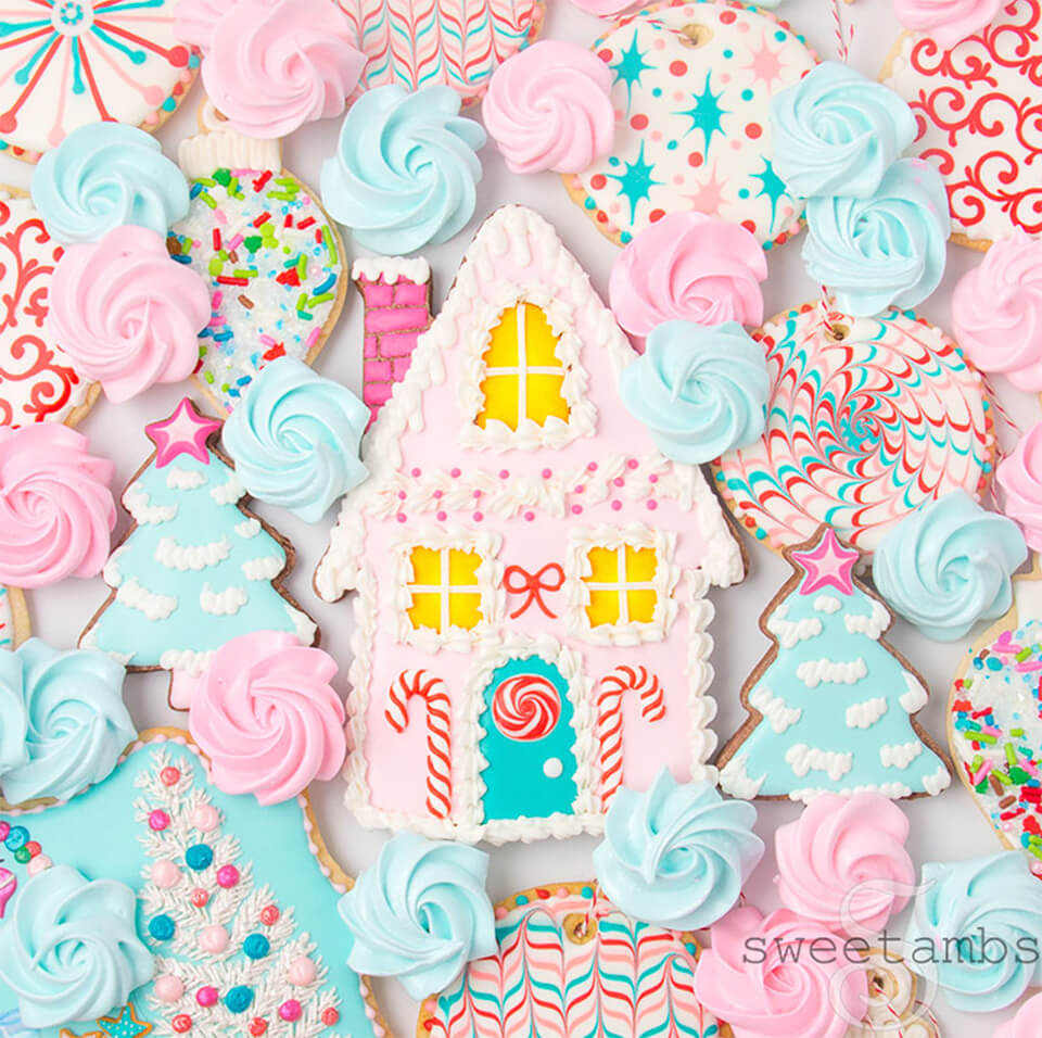 An assortment of pink and blue frosted Christmas cookies and meringues