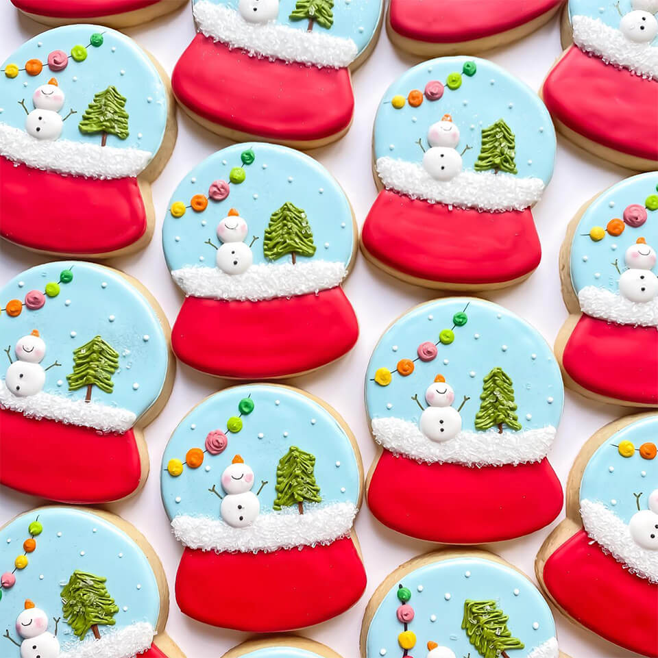 Frosted cookies shaped like snowglobes with a winter scene