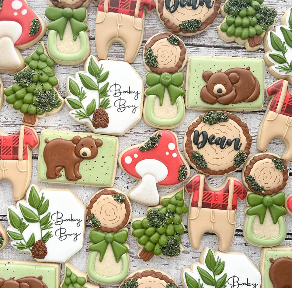 Cookies frosted in in various forest-related designs, with some reading "baby boy" and "Dean"