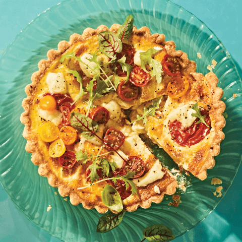 quiche caprese quiche recipe with baked cherry tomaotes on blue background