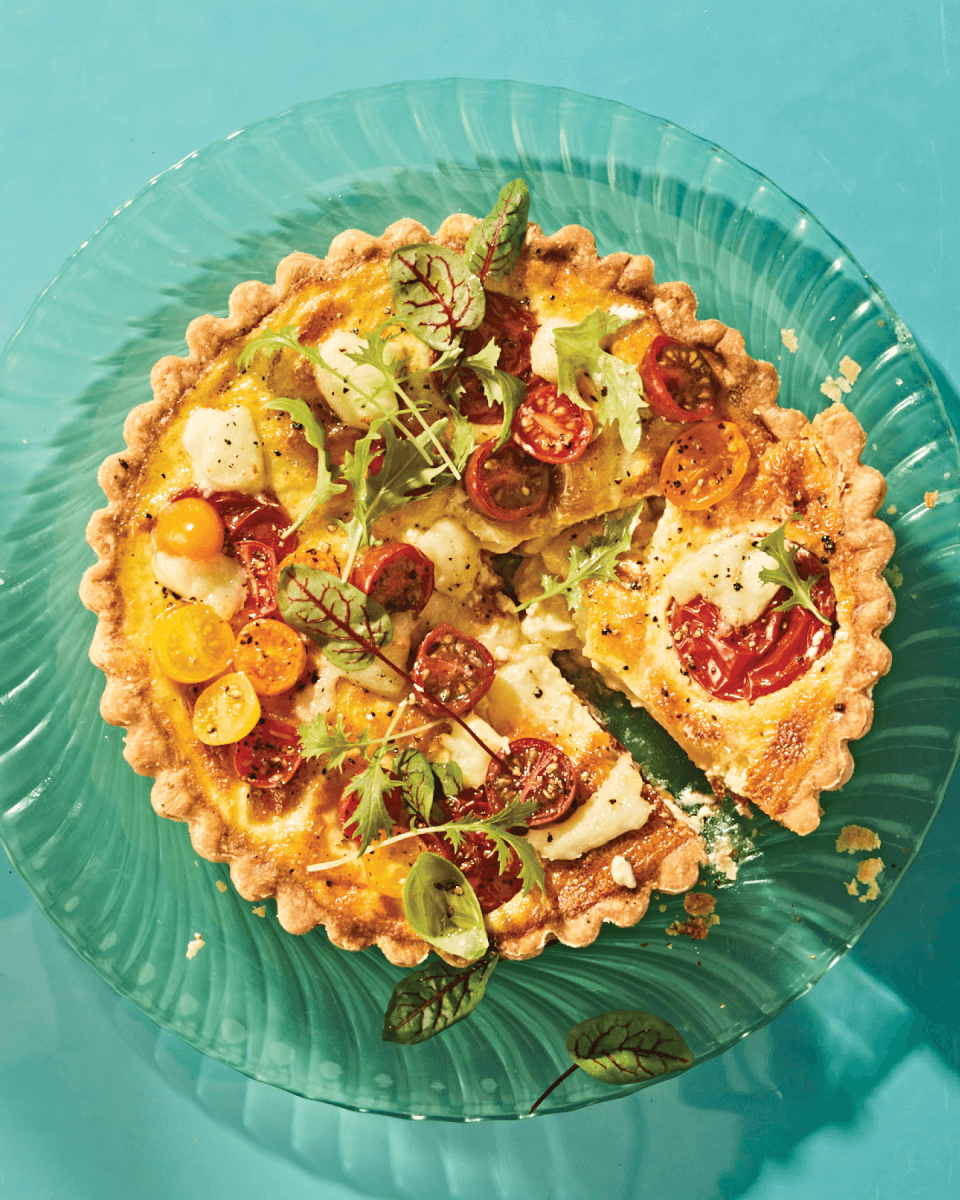 quiche caprese quiche recipe with baked cherry tomaotes on blue background