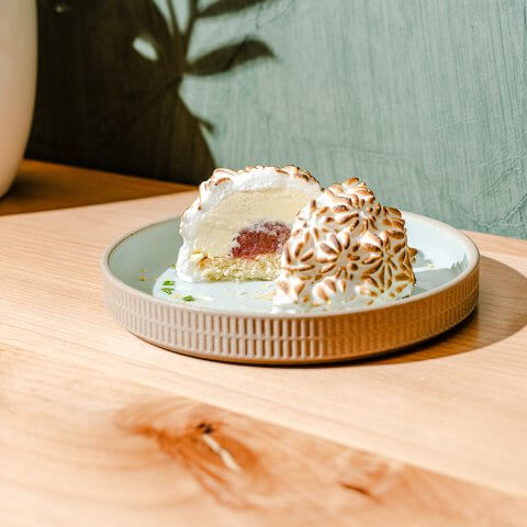 A dessert on a light blue plate on a wooden table with a light blue wall visible behind it