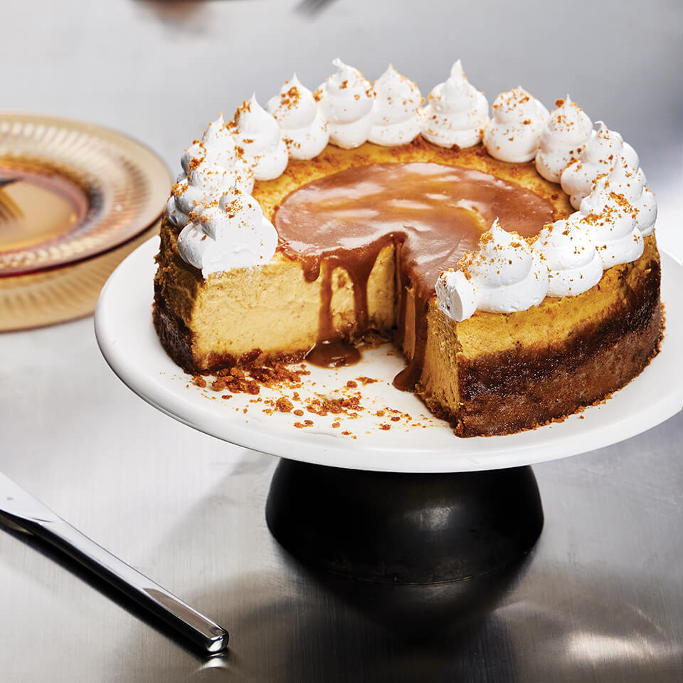 A cheesecake on a black serving stand