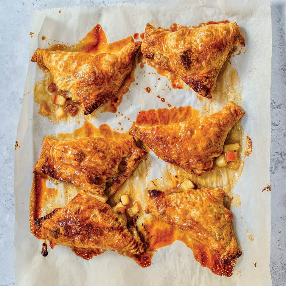 Apple turnovers on a baking tray with parchment paper