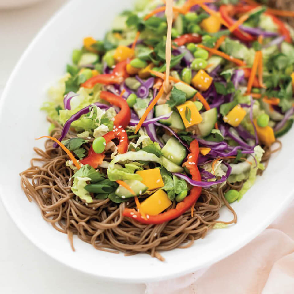 A white dish with soba noodle salad