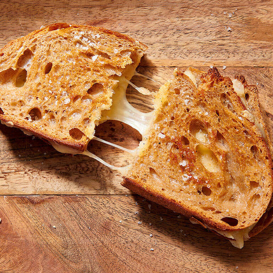 A grilled cheese sandwich on a wooden board