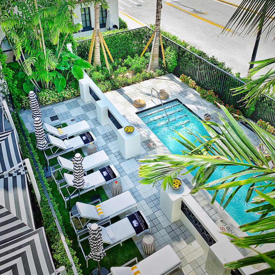 A view of a swimming pool with white lounge chairs at the White Elephant hotel, Palm Beach florida 