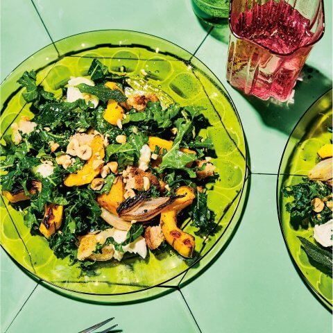 Green plates with a salad on a green surface