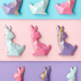 Three rows of three pastel polygon-shaped chocolate Easter bunnies.