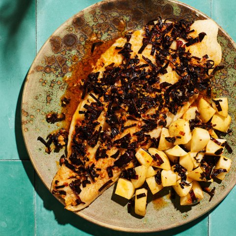 A plate with fish on a blue tile surface