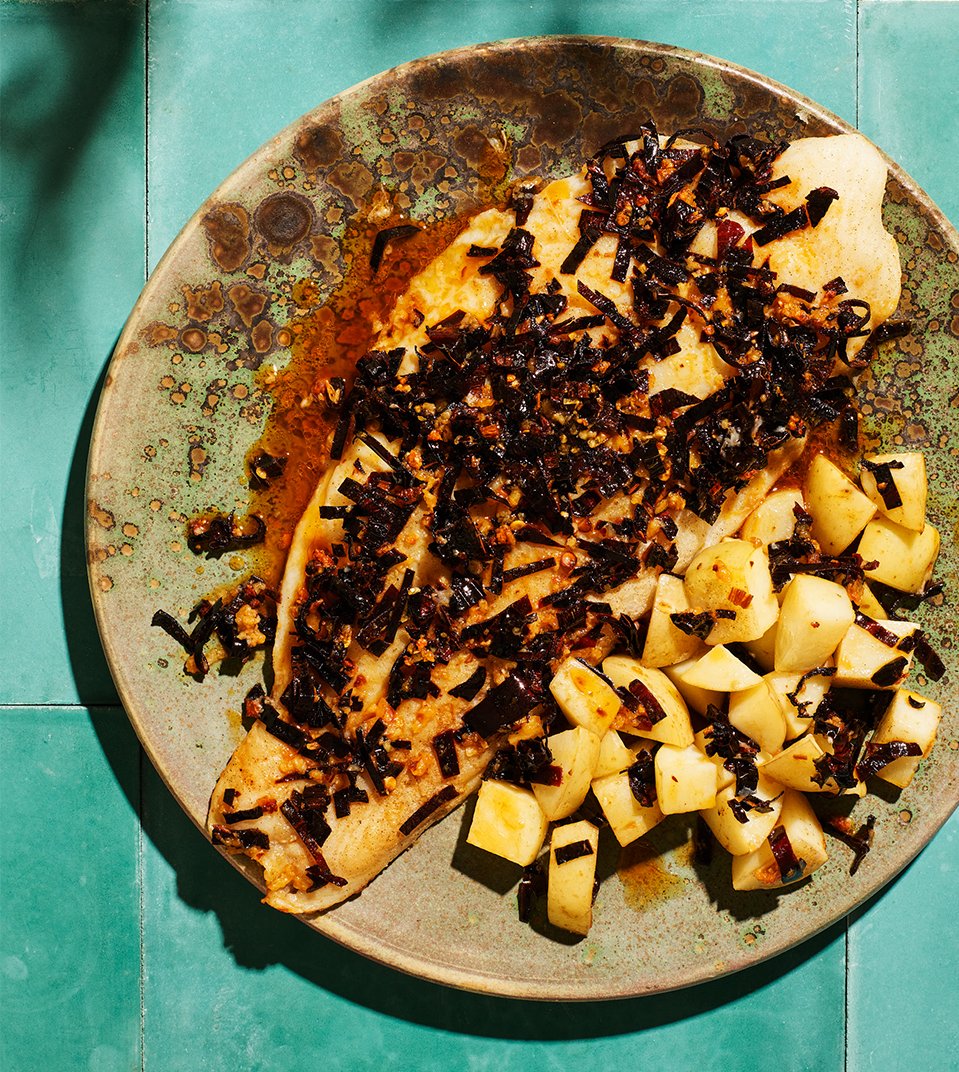 A plate with fish on a blue tile surface