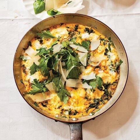 A frying pan with recipe for a frittata and greens