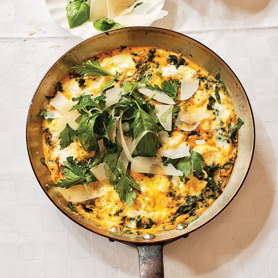 A frying pan with recipe for a frittata and greens