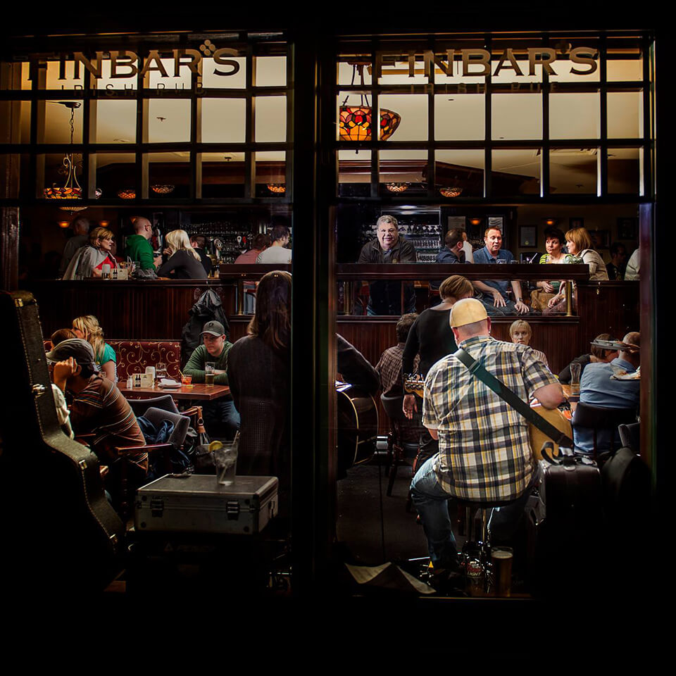 Finbar's Pub in Nova Scotia hosts musicians to play live, like the person here is playing guitar in front of a room of restaurant guests 