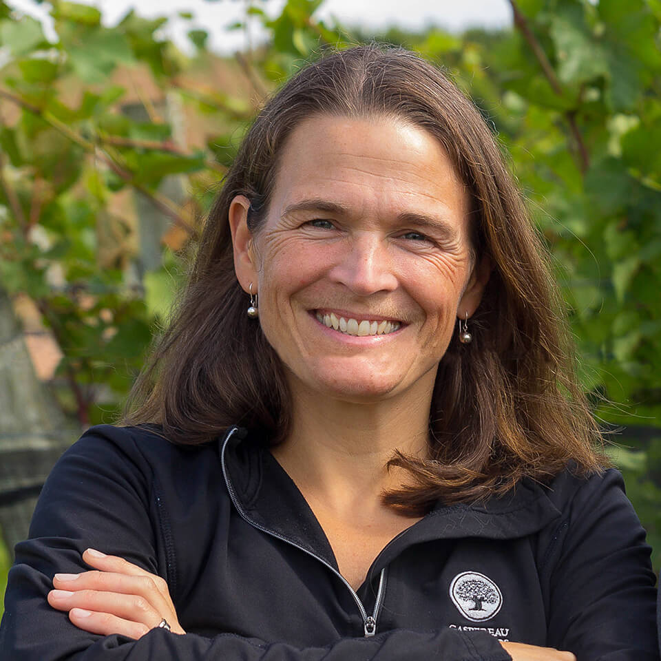 A woman, Gina Haverstock, smiling in a vineyard