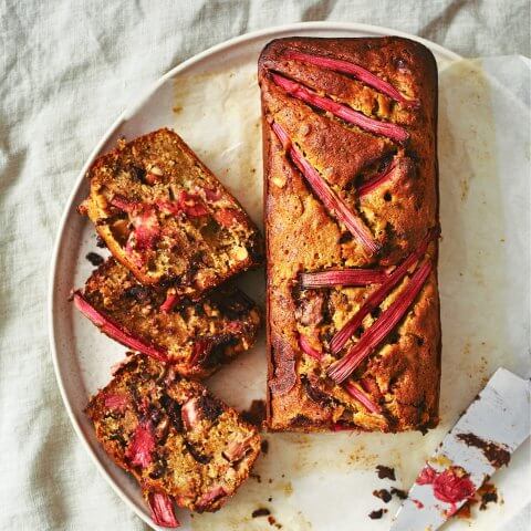 A white plate with a sliced loaf topped with rhubarb